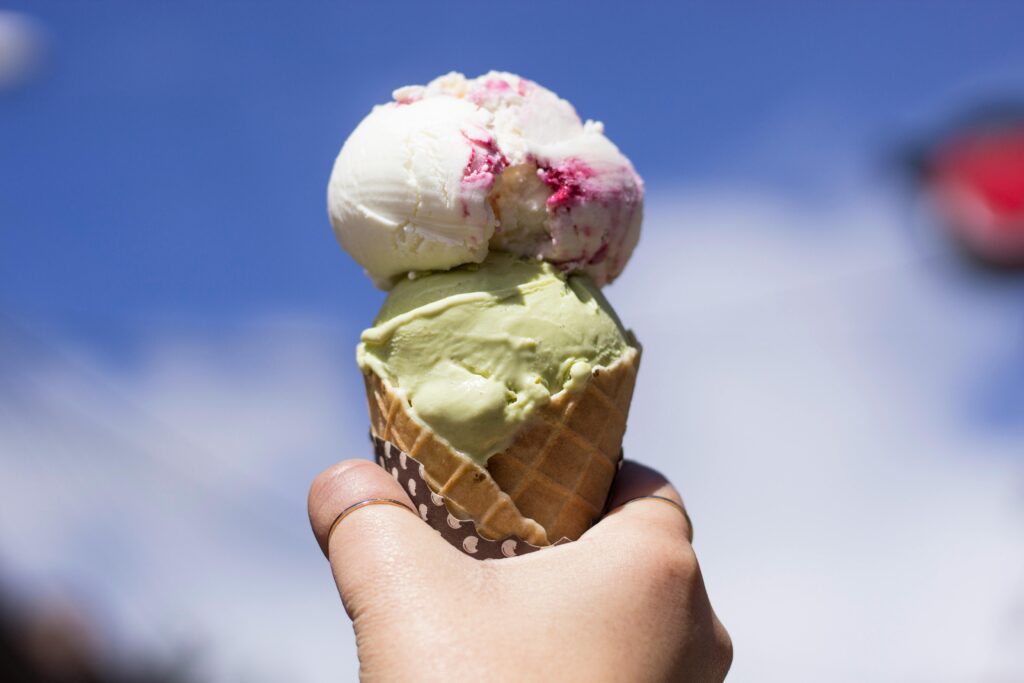 A San Diego traveler holds up the cone of gelato they got in Little Italy.